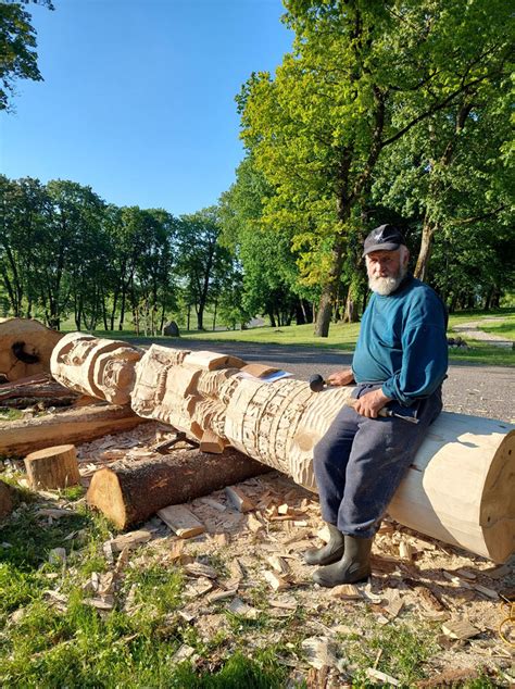 Pranas Petronis dirbtuvėje su medžio drožiniais