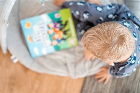 vaikas skaitantis edukacinę knygą