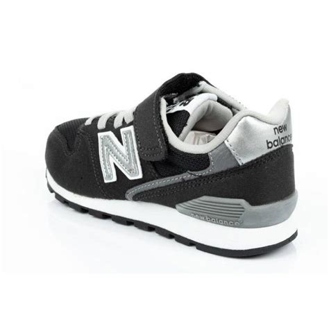 Stilingi vaikiški New Balance kedai ant medinio paviršiaus
