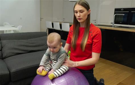 kūdikis atliekantis pratimus ant didelio kamuolio