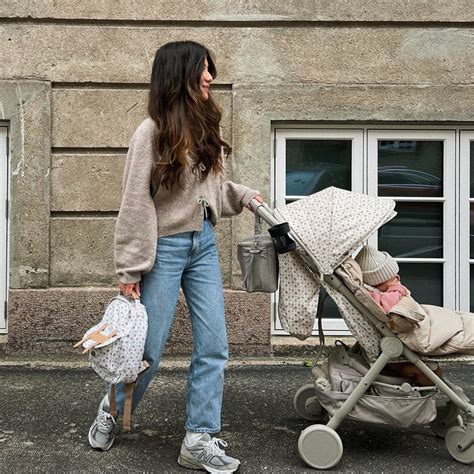 Tėvai su vaiku ir vežimėliu pasivaikščiojime mieste