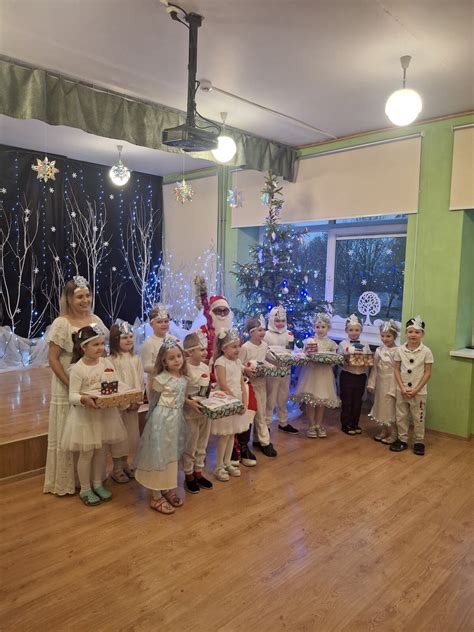 Elfas pasakoja pasaką vaikams prie eglutės
