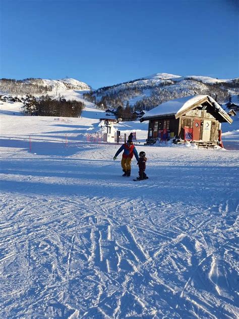 vaikas mokosi čiuožti su snieglente kalnuose