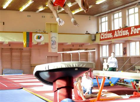 Vaikai atlieka akrobatinius pratimus ant kilimėlio