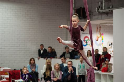 Vaikų grupė atlieka pratimą ant gimnastikos buomo