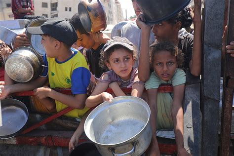 Vaikai, laukiantys maisto porcijų humanitarinės pagalbos punkte Gazoje