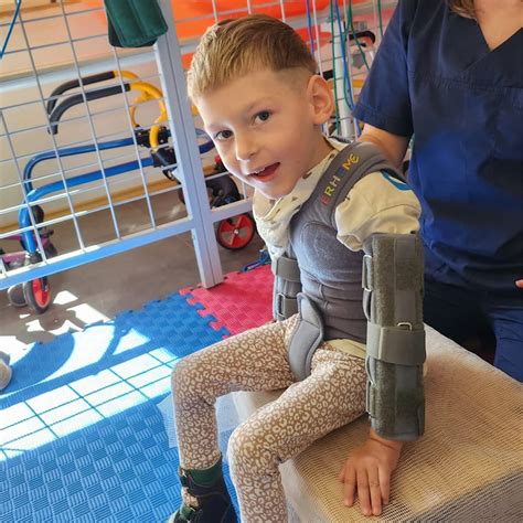 vaikas su cerebriniu paralyžiumi atlieka fizioterapijos pratimus