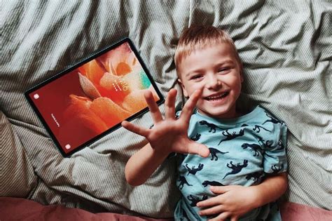 Vaikas, žiūrintis planšetinį kompiuterį