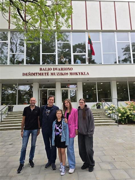 Kūdikis žengia pirmuosius žingsnius, laikydamasis už tėvų rankų
