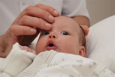 osteopato rankos, atliekančios švelnius judesius kūdikiui