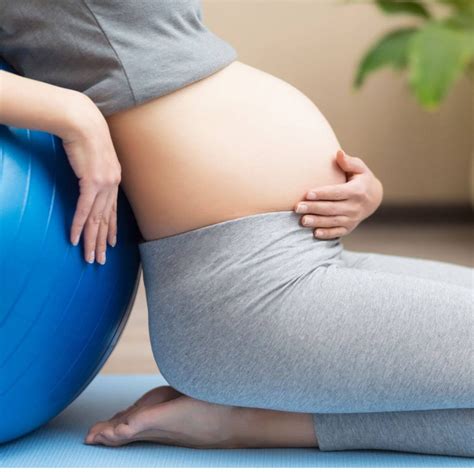 Nėščioji atlieka tempimo pratimus trečiuoju trimestru