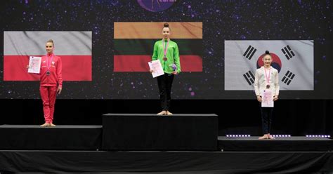 Dalia Kutkaitė apdovanoja jauną gimnastę turnyre