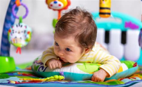 kūdikis gulintis ant pilvuko ant lavinimo kilimėlio