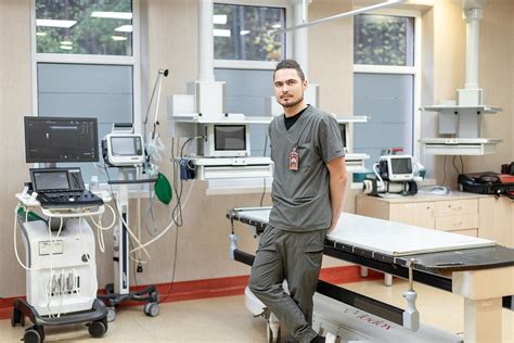 Gydytojas apžiūrintis naujagimį ligoninėje