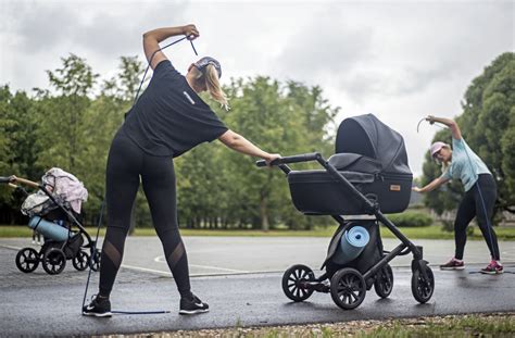 Mama su vaiko vežimėliu aktyviai vaikštanti parke