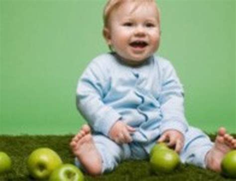 Kūdikis mokosi sėdėti, atsirėmęs rankomis