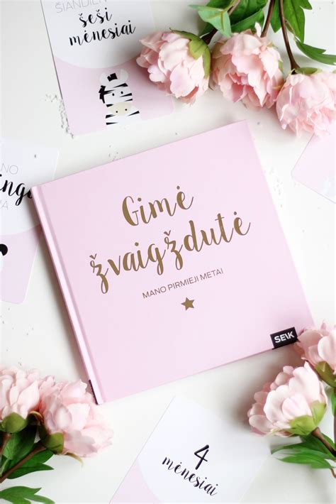 kūdikio prisiminimų knyga ant stalo su nuotraukomis