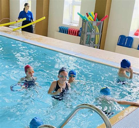 Vaikai baseine su plaukimo priemonėmis