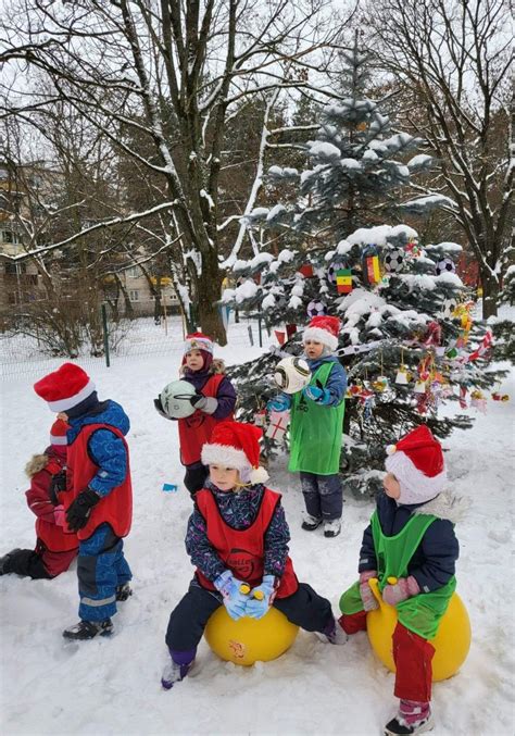 Grupė besišypsančių vaikų, žaidžiančių lauke, pabrėžiant jų fizinį aktyvumą ir gerą savijautą